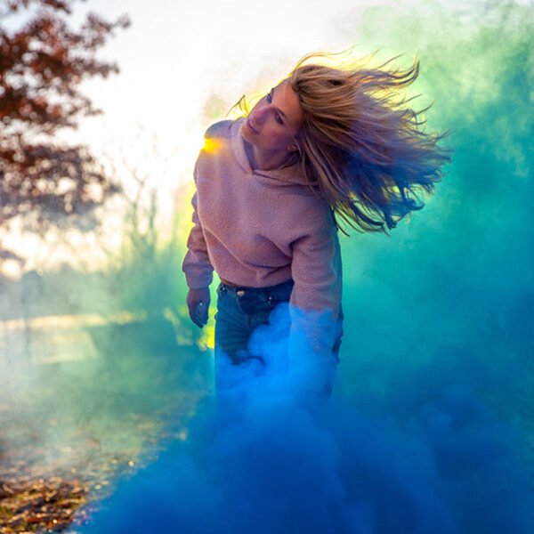 girl with hair in the wind and blue smoke